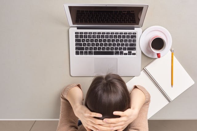 パソコン前で頭を抱える女性