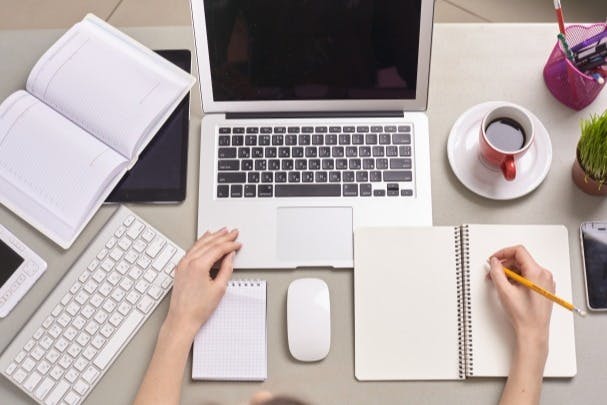 パソコンとコーヒーとメモをとる人