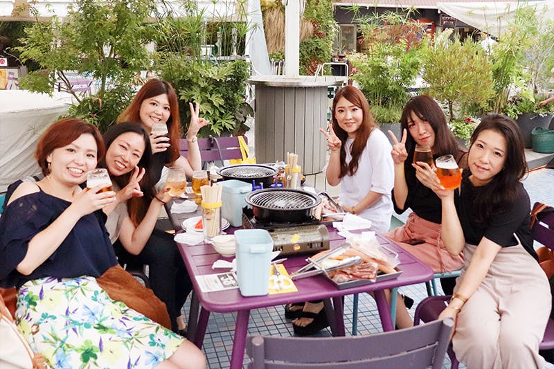 飲み物片手に笑顔でピースをする女性6人