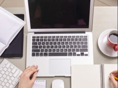 パソコンとコーヒーとメモをとる人