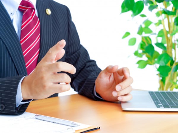 PCとバインダーとスーツの男性の手