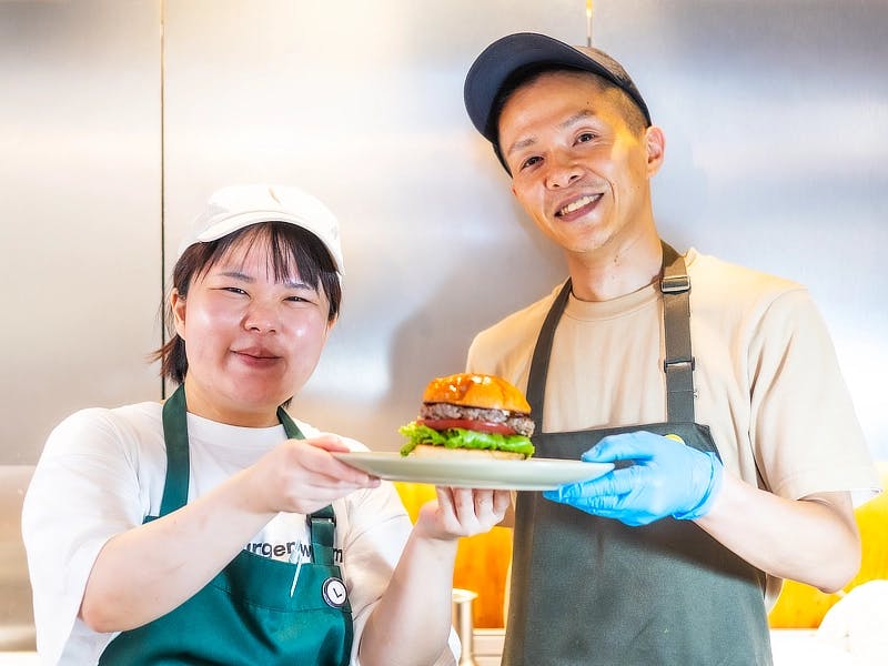 ハンバーガーを持つ笑顔の男女